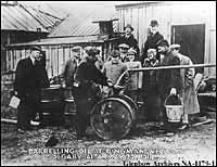 Photo: Barrel being filled with oil from pipe. Dingman well (Calgary Petroleum Products #1), Turner Valley, Alberta. May 22, 1914 (Glenbow Archives NA-1179-1) 